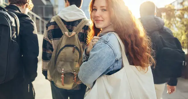 Jongere met tas kijkt om